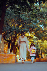 Mother and Daughter Walking Hand in hand Going to School. Mom and little girl on the first day of the school year
