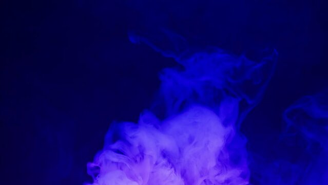 Smoke texture on black background in blue neon light. Smoking, steam clouds of vapour close-up. Burning, fog. 