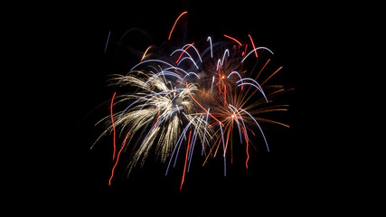 Close-up color photo of a vibrant red, white and blue fireworks display with copy space