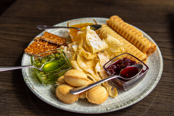 Assorted oriental sweets and jam on a plate. Nuts and tubes with condensed milk 