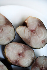 Sliced smoked Scomber on a white plate. Fish appetizer.