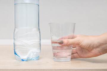 female hand holding a glass of clean water. man pours fresh water into a glass. clean drinking water. 