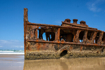 Old shipwreck on the beach with the ocean behind