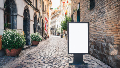 Outdoor mockup of a blank information poster on patterned paving-stone; an empty vertical street...