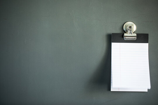 Lined note paper on dark gray magnet board