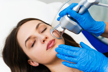 Process of facial CO2 laser resurfacing. Cosmetologist removes wrinkles and scars using laser from...