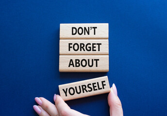 Do not forget about yourself symbol. Concept words Do not forget about yourself on wooden blocks. Businessman hand. Beautiful deep blue background. Business concept. Copy space