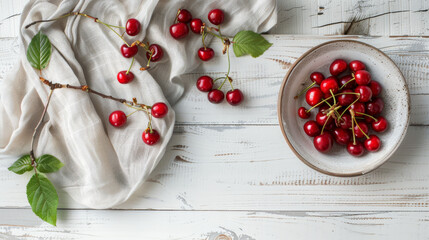 Fresh cherries arranged on a rustic white table, some in a bowl, others scattered with twigs and leaves, creating a charming, rustic still-life.