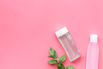 skin care cosmetics with facial tonic, mycelial water and plant on pink background top view mockup