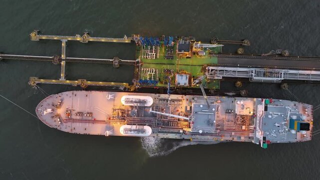 Aerial drone view of a LNG Supertankers Docked in Port Awaiting Offloading and Loading of Fuels and Cargo Petroleum Tanker Vessel Chemical or Methane freighter export import. Night view