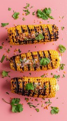Grilled corn on the cob with cilantro and salt on a pink background