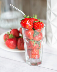 strawberry season, ripe juicy berries on the table in a cocktail glass and on a plate. High quality photo
