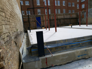 Construction site with service pipes and drainage installation through a concrete slab, rebar mesh, and insulation boards.