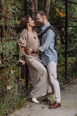 Love, hug and happy with couple in park for romance, bonding and summer vacation. Loving young couple hugging and smiling together on nature background. Beautiful girl with tattooed body outdoor.