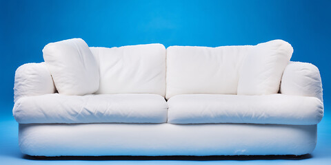 White fluffy couch on blue background, minimalist style, inviting comfort and relaxation. 
