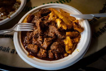 Beef goulash with roasted potatoes, served on the plastic plate in the Budapest city market, one of many famous hungarian dishes