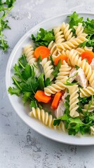 A white plate with spaghetti pasta, chicken, broccoli, carrots, and peas