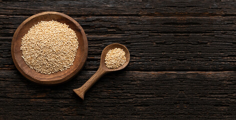 Chenopodium quinoa - White organic quinoa seeds in the bowl and spoon - Rustic background