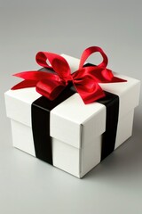 Obraz premium A beautifully wrapped gift box tied with a red ribbon, suitable for special occasions and celebrations