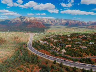 Desert and mountain range overlooking houses and highway traffic in the town of Sedona, Arizona, United States.