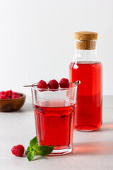 Raspberry drink in the glass on the light background.