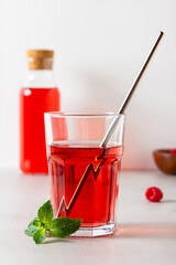 Raspberry drink in the glass on the light background.