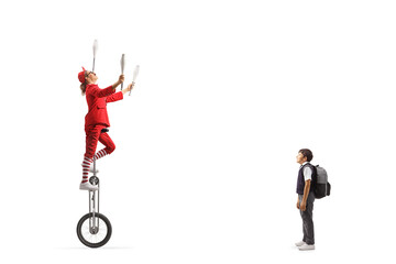 Schoolboy watching an acrobat riding a giraffe unicycle and juggling © Ljupco Smokovski