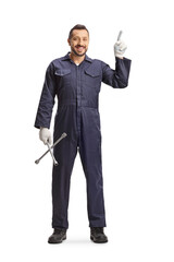 Car mechanic holding a wrench and pointing up