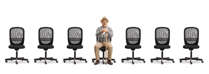 Elderly man sitting on a desk chair with empty chairs in a line