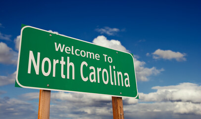 Welcome To North Carolina Green Road Sign Over Blue Sky with Some Clouds. © Andy Dean