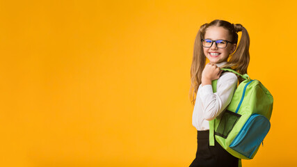 Schoolgirl Posing With School Backpack Smiling To Camera Standing Over Yellow Background. Studio...