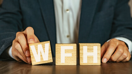 There is wood cube with the word WFH. It is an abbreviation for Work From Home as eye-catching...