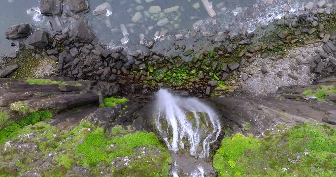 Aerial birds eye view of pulling up from Mealt falls and Kilt rock in the Scottish Highlands of Portree, Isle of Skye
