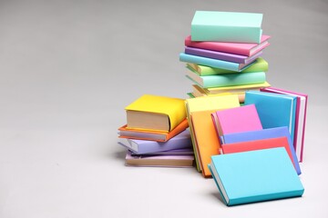 Stacks of colorful books on light grey background