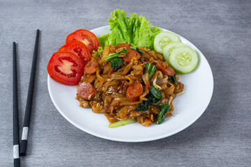 Kwetiaw or Kwetiau, fried rice noodles with sausage, egg and vegetables. Perfect for recipe, article, catalogue, promotion, or any cooking contents.