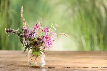 Bouquet of different healing herbs on wooden table. Space for text