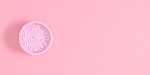 Top view photo of pink alarm clock on isolated pastel pink background with blank space. banner