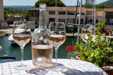 Glasses of cold rose gris Cote de Provence wine in yacht harbour of Port Grimaud, summer vacation on French Riviera in Provence, France