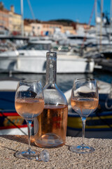 Glasses of cold rose Cote de Provence wine in old fisherman boats and yacht harbour in Saint-Tropez, summer vacation on French Riviera in Provence, France