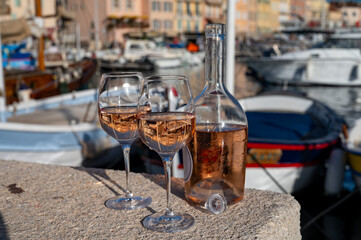 Glasses of cold rose Cote de Provence wine in old fisherman boats and yacht harbour in Saint-Tropez, summer vacation on French Riviera in Provence, France