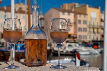 Glasses of cold rose Cote de Provence wine in old fisherman boats and yacht harbour in Saint-Tropez, summer vacation on French Riviera in Provence, France