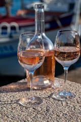 Glasses of cold rose Cote de Provence wine in old fisherman boats and yacht harbour in Saint-Tropez, summer vacation on French Riviera in Provence, France