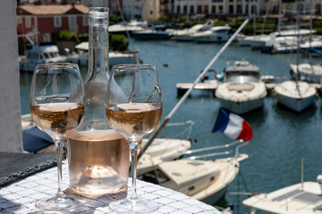 Glasses of cold rose gris Cote de Provence wine in yacht harbour of Port Grimaud, summer vacation on French Riviera in Provence, France