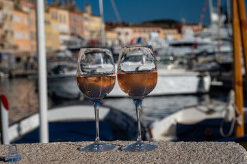 Glasses of cold rose Cote de Provence wine in old fisherman boats and yacht harbour in Saint-Tropez, summer vacation on French Riviera in Provence, France