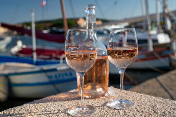 Glasses of cold rose Cote de Provence wine in old fisherman boats and yacht harbour in Saint-Tropez, summer vacation on French Riviera in Provence, France