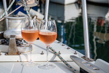Party with rose wine on yacht boat anchored in port la Rague, Gulf of La Napoule, in Provence, two glasses of cold rose wine, French Riviera near Cannes, south of France