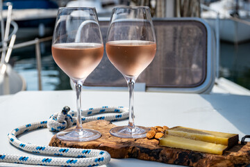 Party with rose wine on yacht boat anchored in port la Rague, Gulf of La Napoule, in Provence, two glasses of cold rose wine, French Riviera near Cannes, south of France