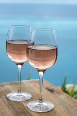 Summer time in Provence, two glasses of cold rose wine with blue sea view on background, French Riviera near Menton, south of France