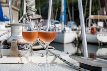 Party with rose wine on yacht boat anchored in port la Rague, Gulf of La Napoule, in Provence, two glasses of cold rose wine, French Riviera near Cannes, south of France