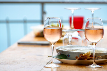 Summer time in Provence, two glasses of cold rose wine with blue sea view on background, French Riviera near Menton, south of France